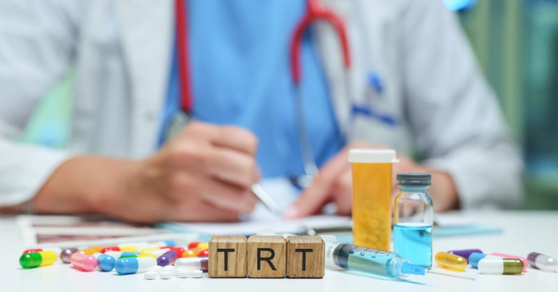 A doctor writing on a desk covered in pills and other medicines. Three wood blocks on the desk spell the acronym “TRT.”