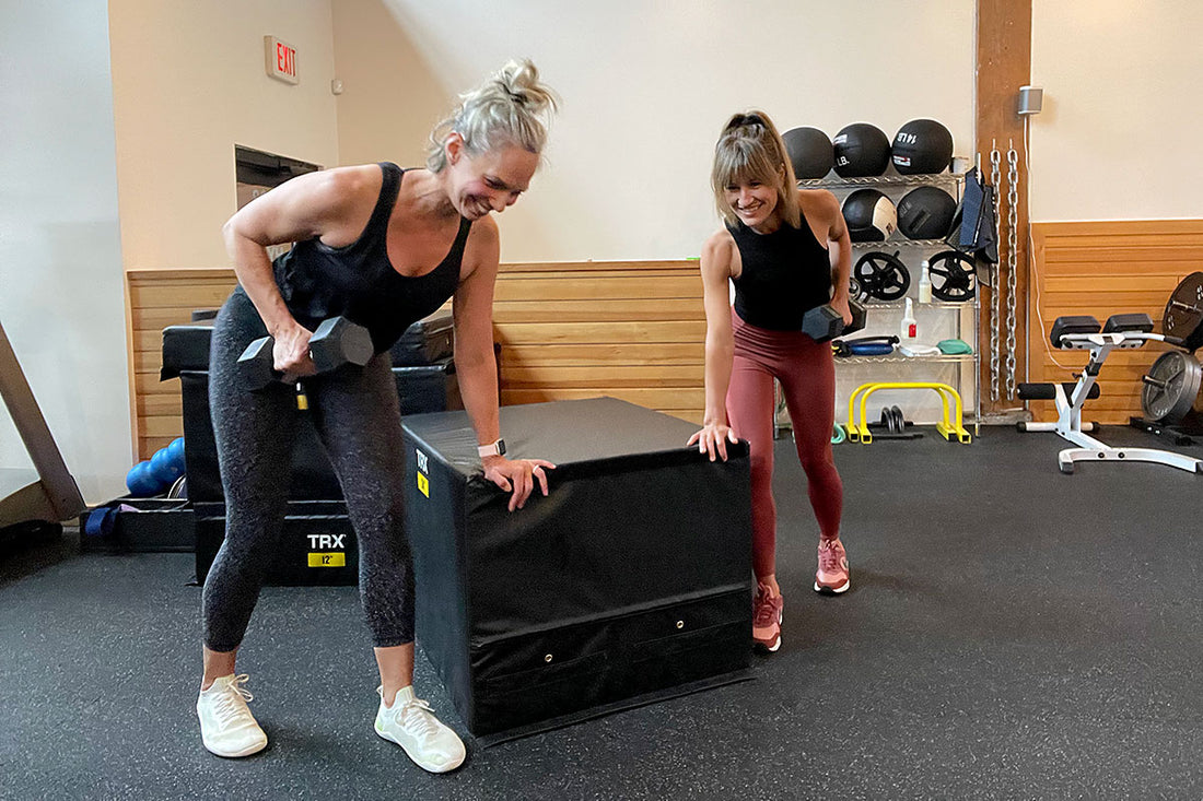 2 women lifting weights to show importance of strength training for women